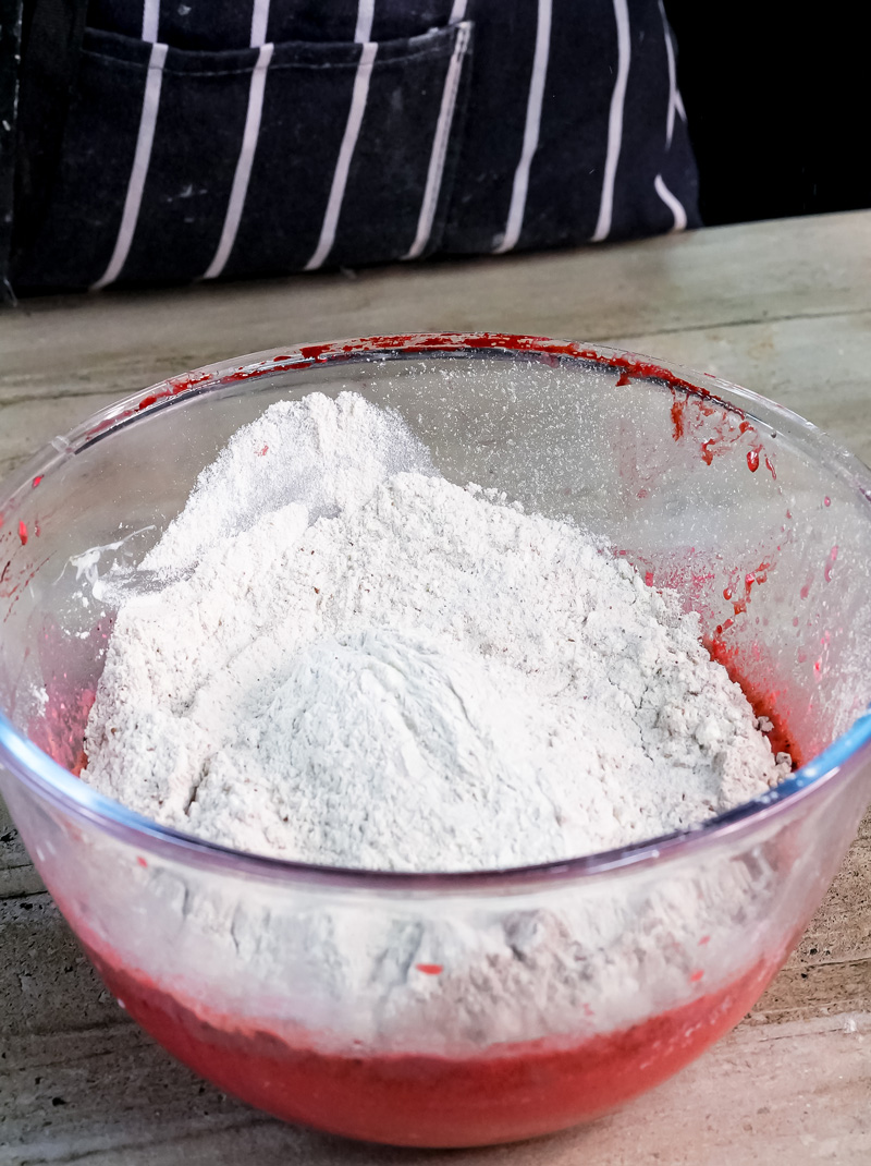 Red velvet pancake batter with flour being mixed