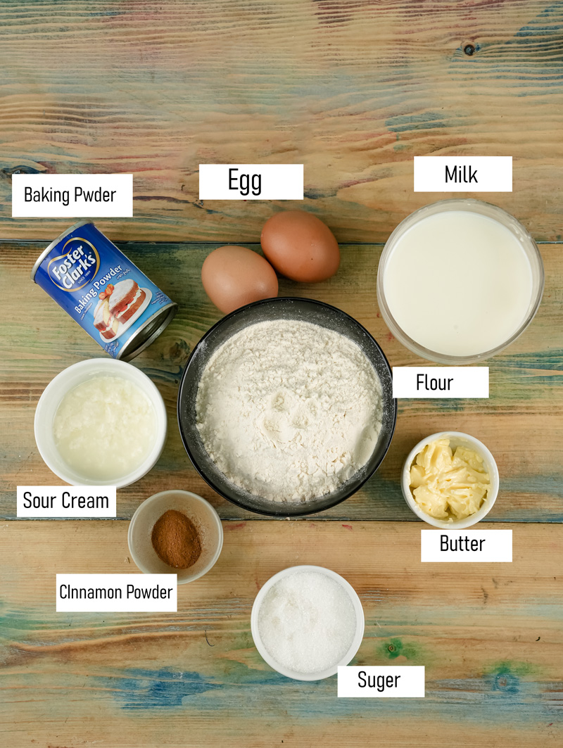 Silver dollar pancakes ingredients including flour, eggs, milk, butter, and spices on wooden surface