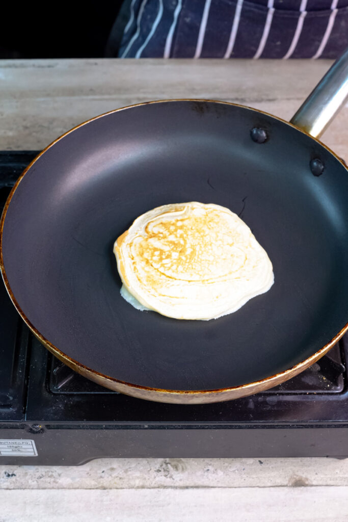 Pouring pancake batter into pan to make silver dollar pancakes