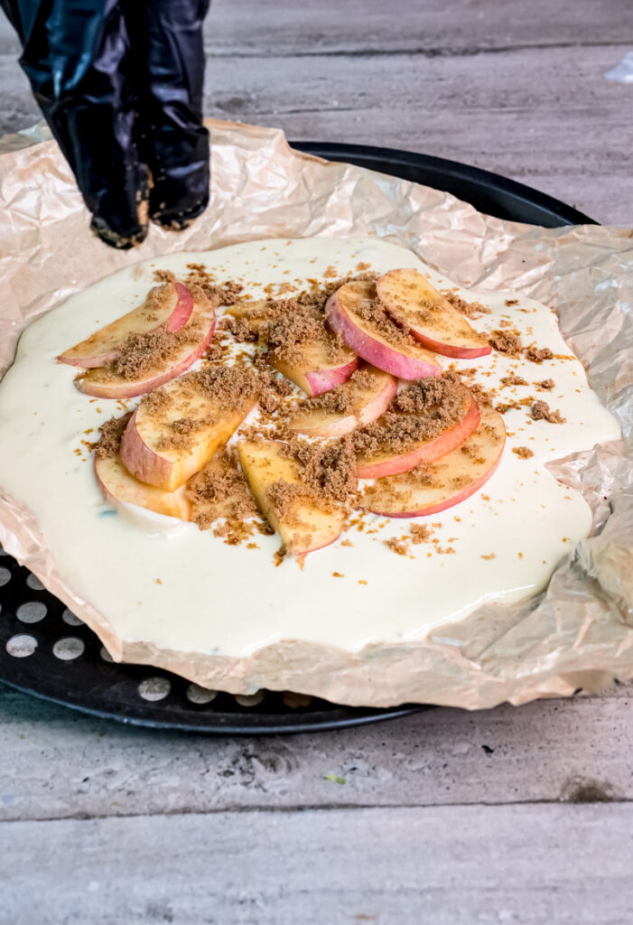 Sprinkling cinnamon sugar over German Apple Pancake before baking