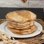 Whole wheat pancakes with honey drizzle on serving plate