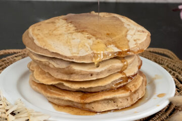 Whole wheat pancakes with honey drizzle on serving plate