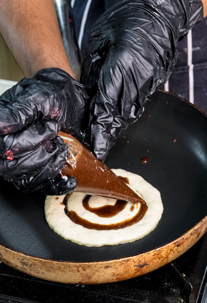 Creating cinnamon roll swirl pattern in pancake batter with knife
