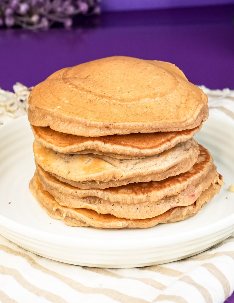 Stack of fluffy peanut butter pancakes on white plate