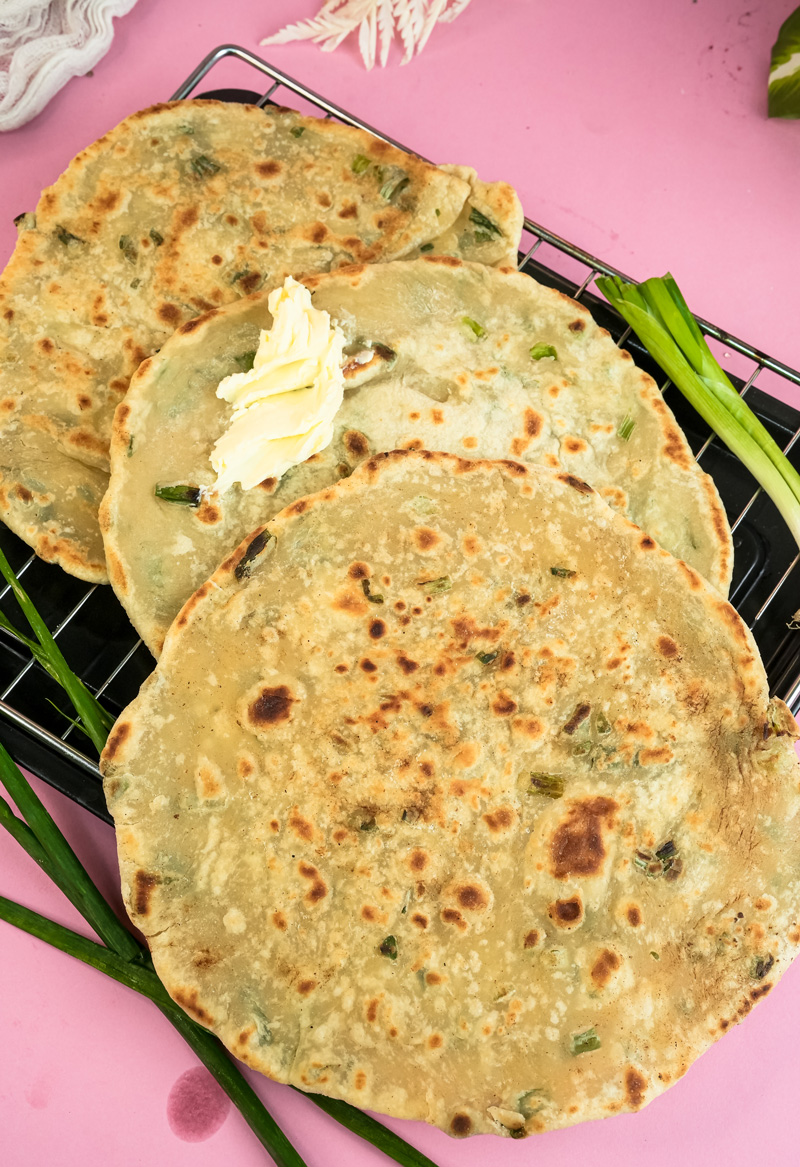 Finished golden Chinese scallion pancakes cooling on wire rack