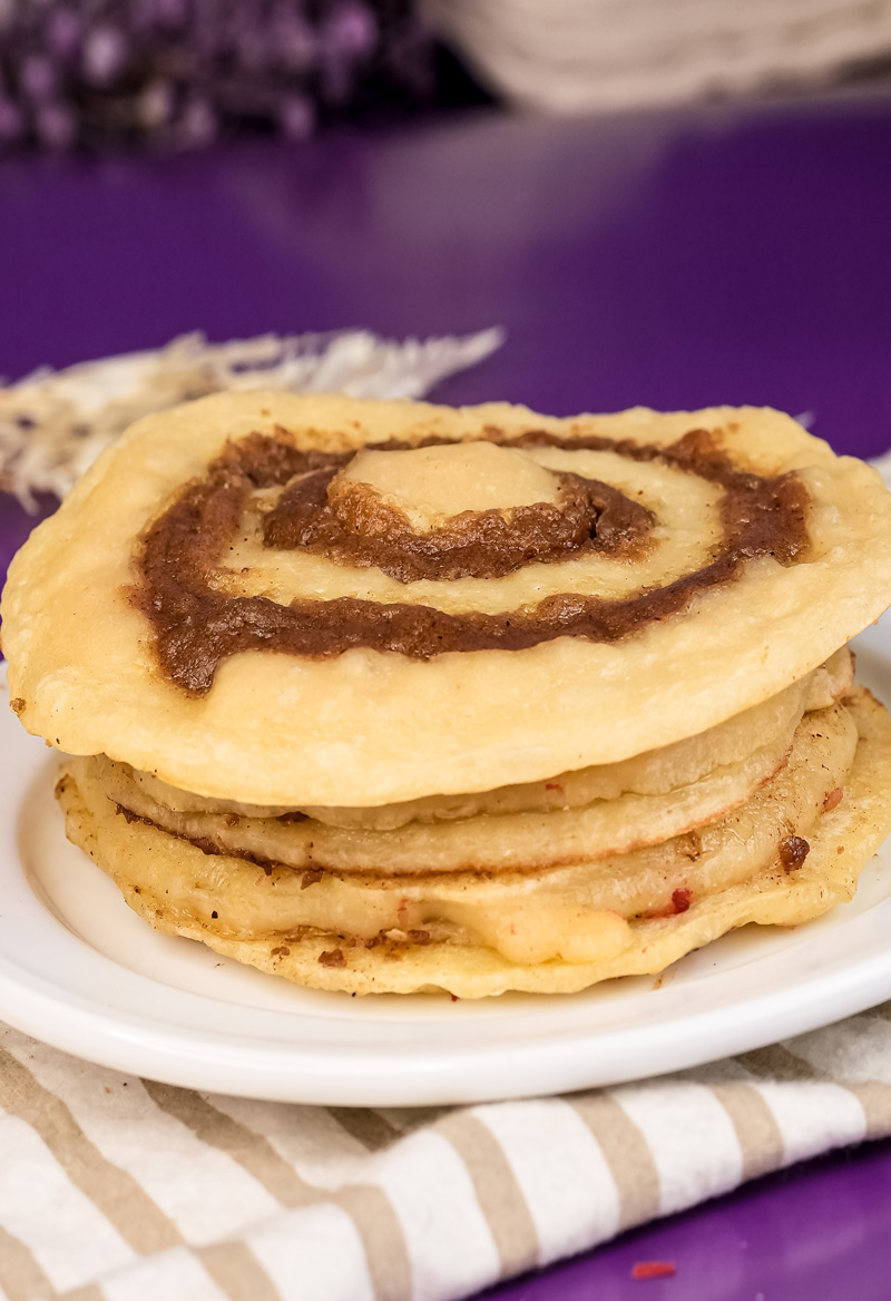 Side view of stacked cinnamon roll pancakes showing layered spiral design